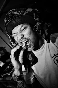 a black and white photo of a man chewing on a cigarette