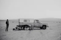 a man standing next to a camper in the desert